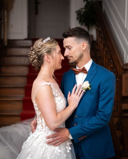 Les mariés se regardent enlacés au pied du grand escalier du Manoir - Photographe mariage Yvelines
